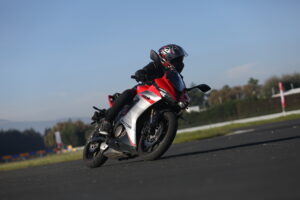 Motocicleta deportiva roja QJMOTOR tomando una curva en pista