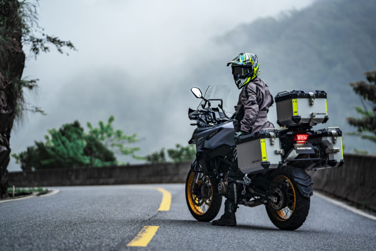 Motocicleta adventure QJMOTOR estacionada en carretera de montaña